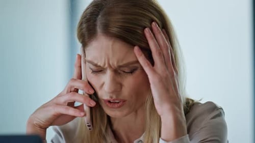 Upset woman arguing on phone call in office