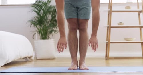 Man Stretching on Yoga Mat in Bright Room