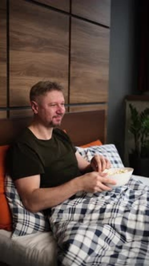 Man Watching Funny Tv Show And Eating Popcorn