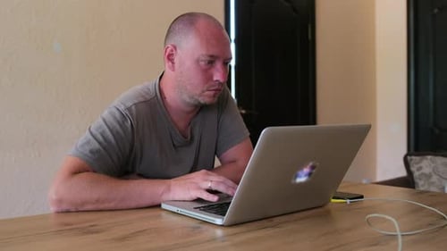 Freelancer, designer man working by typing on keyboard and look at monitor, programmer work in home