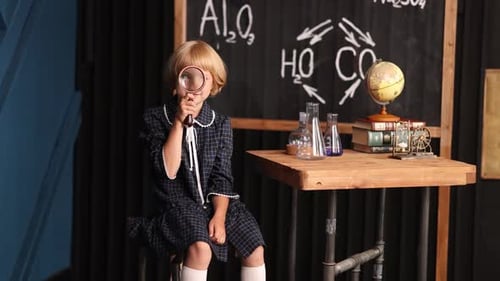 Smiling Child with Magnifying Glass in Classroom