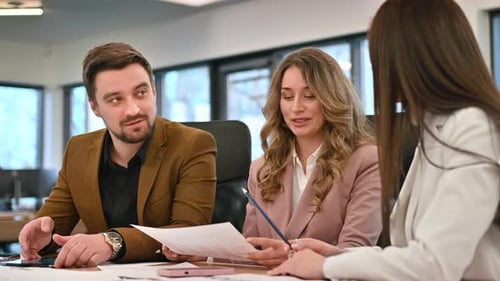 Business meeting in an office, workers discussing business affairs using papers. Slow motion