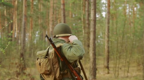 Als amerikanische Soldaten der US-Infanterie des Zweiten Weltkriegs verkleideter Mann marschiert entlang der Forest Road