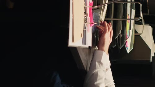 Hands Flip Through Pages of Notes in Office