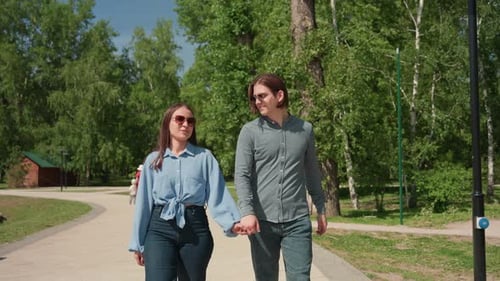 Joyful Couple Strolling Couple in Denim Enjoying Outdoors Smiling Pair Walking Together Through Park