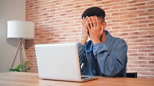 Worried Man Works At Laptop In His Home
