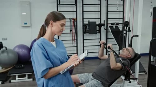 Portrait of Positive Young Female Rehabilitation Specialist Holding Clipboard