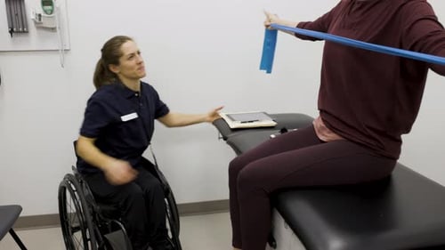 Woman using resistance band with physical therapist