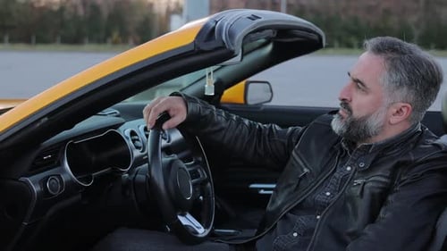 Man in Car A Thoughtful Mature Man in a Leather Jacket Sitting in a Convertible Car