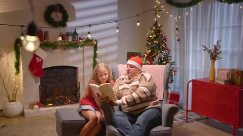 Grandfather and Granddaughter Reading a Book at Christmas
