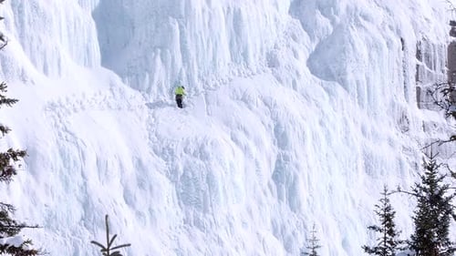 Ice Climber Ascends a Snowy Mountain in Winter