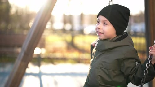 L'enfant sourit et aime se balancer