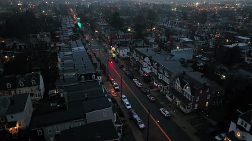 Dark American neighborhood with Main Street and parking cars at night. Foggy winter day in town of U