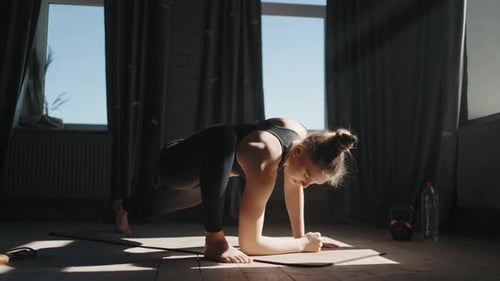 Woman Doing Yoga Twists in Sunlit Room