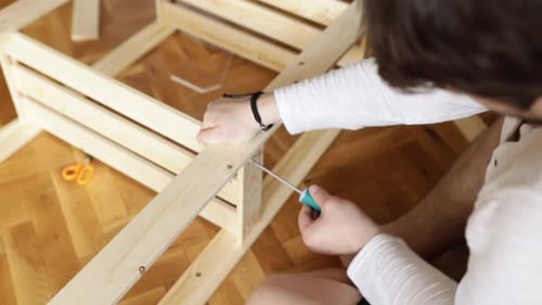 Man Assembling Wooden Furniture at Home