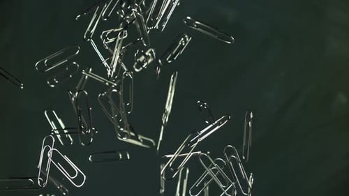 Falling Paper Clips on Dark Gray Background