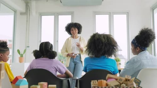 Woman Teaching Children in a Sunny Classroom