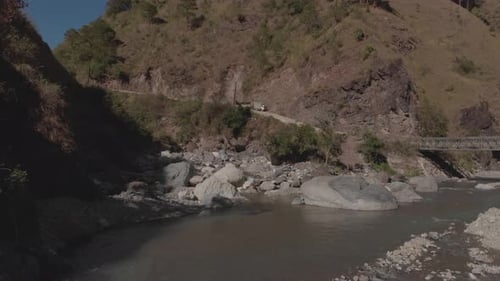 felsiger Fluss schlängelt sich durch Berge im Canyontal, Wasser fließt, nähert sich grauen Felsbrocken, grün
