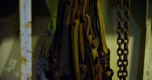 Old Chains Bundled Beside Rugged Crates and Machinery