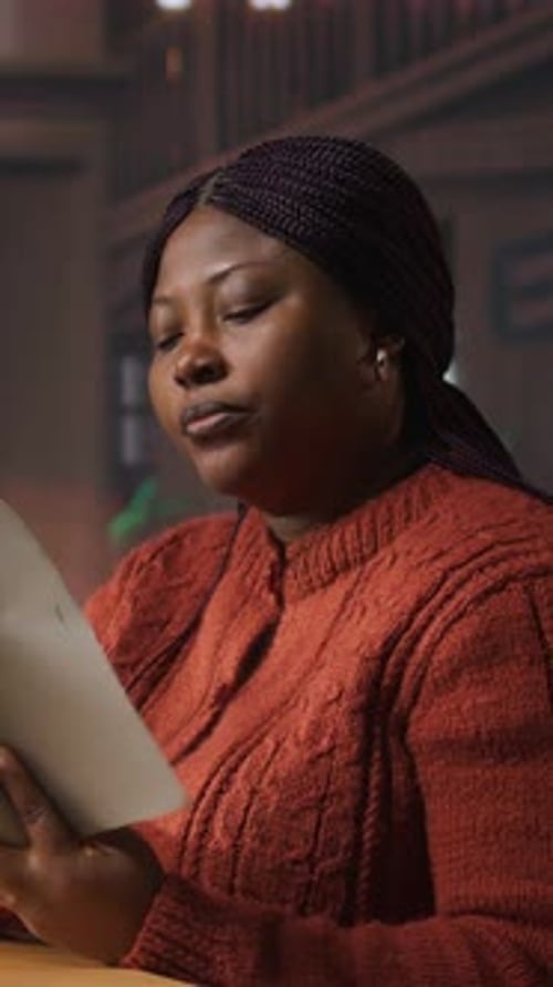 Young Woman Reading Book in a Library