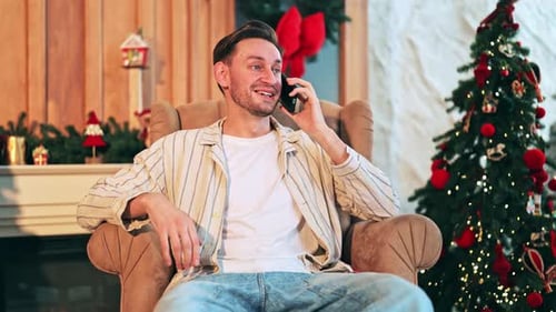 Man Talking on Phone by Christmas Tree