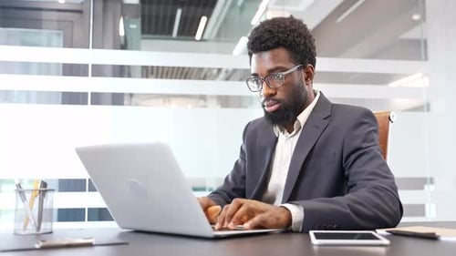 Young Adult Working at Laptop in Modern Office