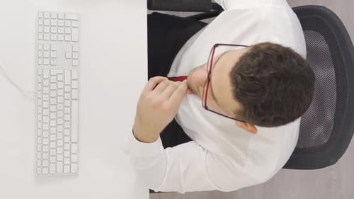 Vertical Video of Tired businessman works in office and is overwhelmed.