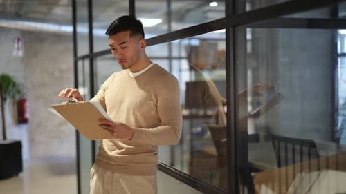 Empresário asiático sorridente estendendo aperto de mão no escritório