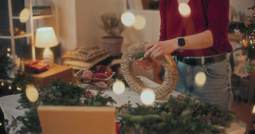 Person Crafting Holiday Wreath at Home