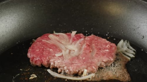 Cooking American Fat Smash Burger with Fresh Onion on Top on Grill Closeup Beef or Pork Cutlet