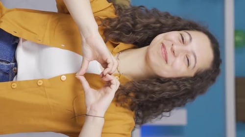 Happy Young Adult Makes Heart Shape with Hands
