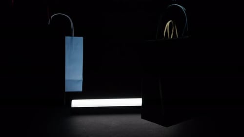 Colorful Shopping Bags Suspended in Dark Studio