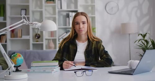 Young Woman Studying at Desk in Home Office