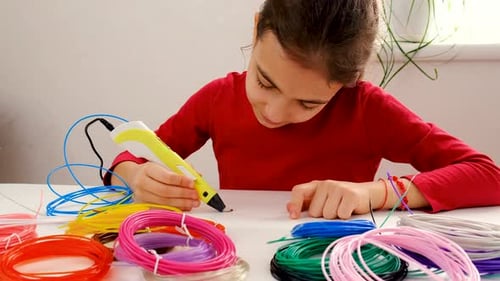 Child Creating with 3D Printing Pen at Table