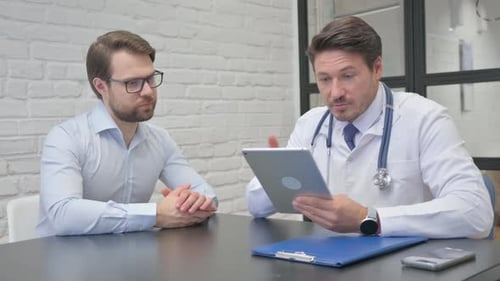 Doctor Explains Results to Patient Using Tablet
