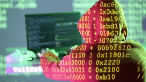 Hooded Hacker Working at Night on Computer Code