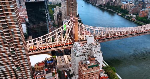 One of the waterfront sides of Queensboro Bridge with huge buildings surrounding it.