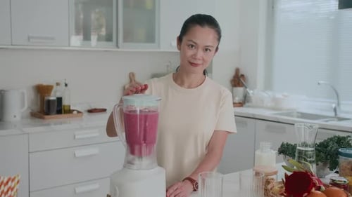 Woman Preparing a Smoothie in a Modern Kitchen