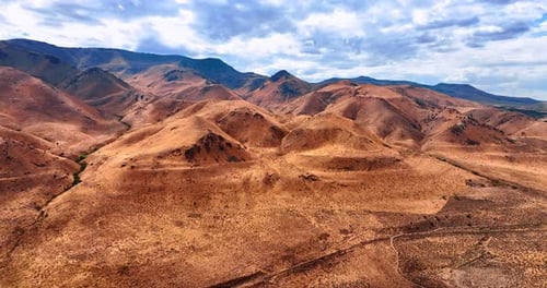 Bare brown rocky landscape with no vegetation. Overcast sky over the scenery.