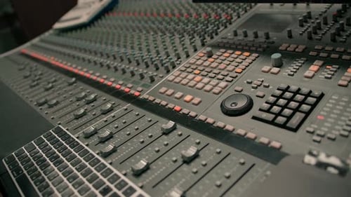 A recording studio control panel mixer with an equalizer faders buttons for broadcasting a recording