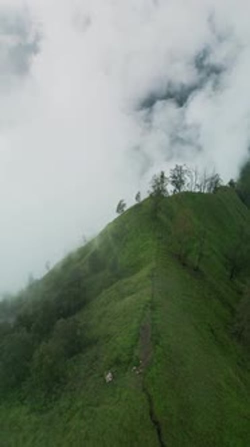 Vidéo de Trunyan Hill Bali filmée par Drone vertical avec de doux nuages flottant au-dessus des hautes terres verdoyantes