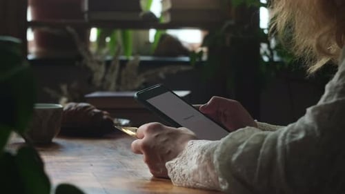 Person Paying Online Using Bank Card and Smartphone Indoors