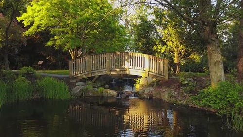 Lake at a Park with a Wooden Bridge Across a Running River