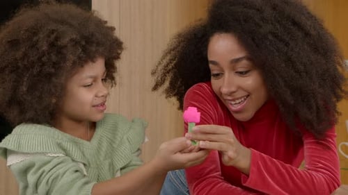Happy School Age Black Daughter Surprising Mother with Handmade Playdough Toy