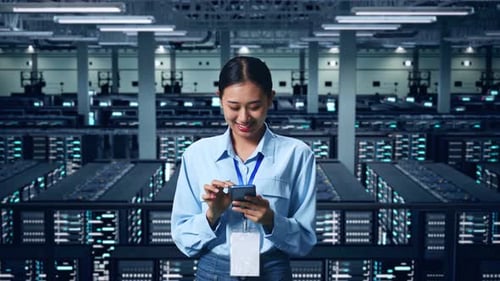 An Asian Business Woman Using Mobile Phone In Data Center