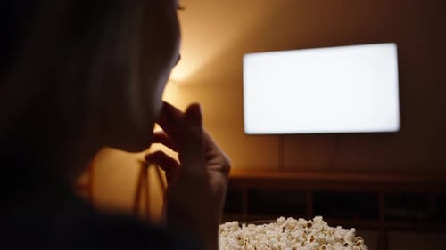Woman Watching TV and Eating Popcorn at Night