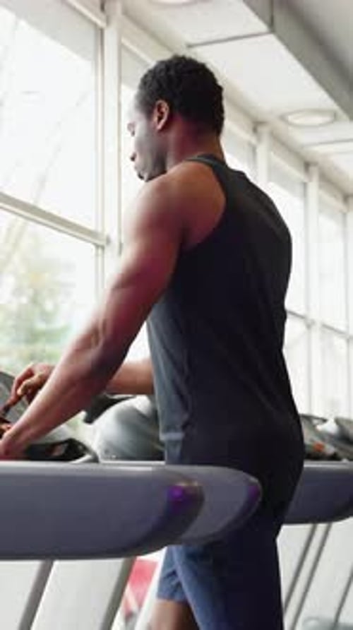 Fit Man Exercising on a Running Machine at the Gym Vertical Video