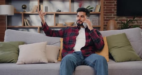 Man Relaxing on Couch While Talking on Cell Phone