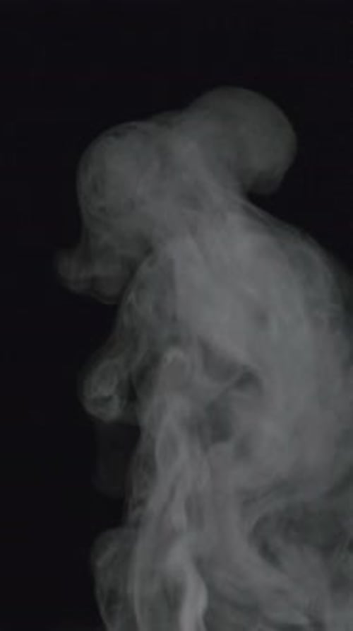 Wispy White Smoke Rising Against Black Background