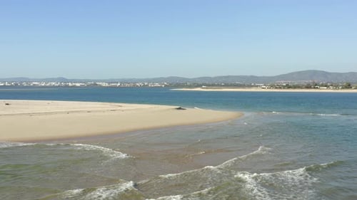 Wunderschöner goldener Strand, umgeben von perfektem blauem Wasser und Baden im Sonnenlicht, Algarve Portugal